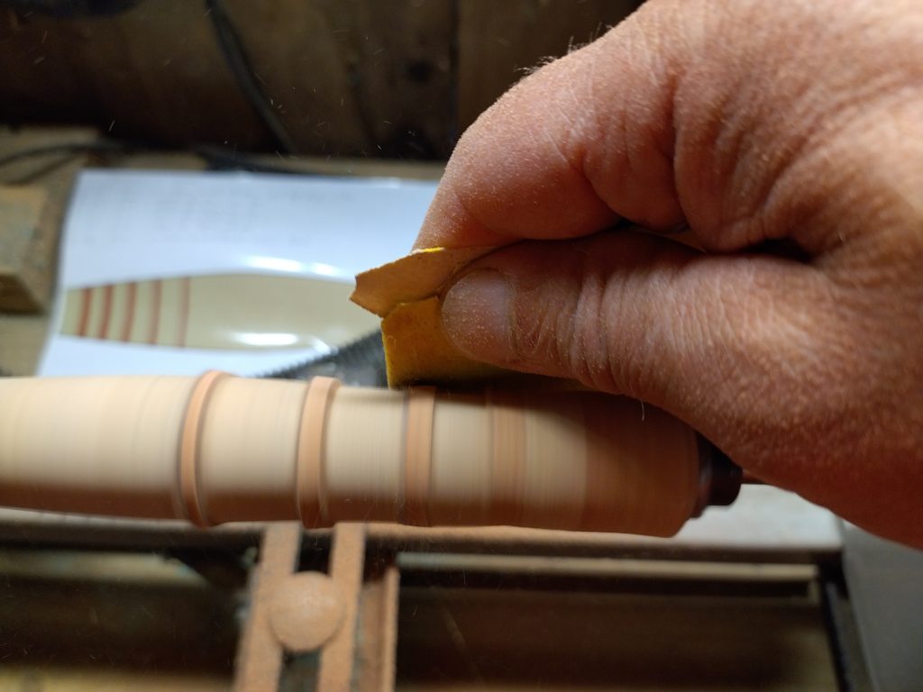 Ponçage d'une poignée liège pour une canne à mouche dans l'atelier de la Canne Normande, préparée pour l'ouverture de la pêche